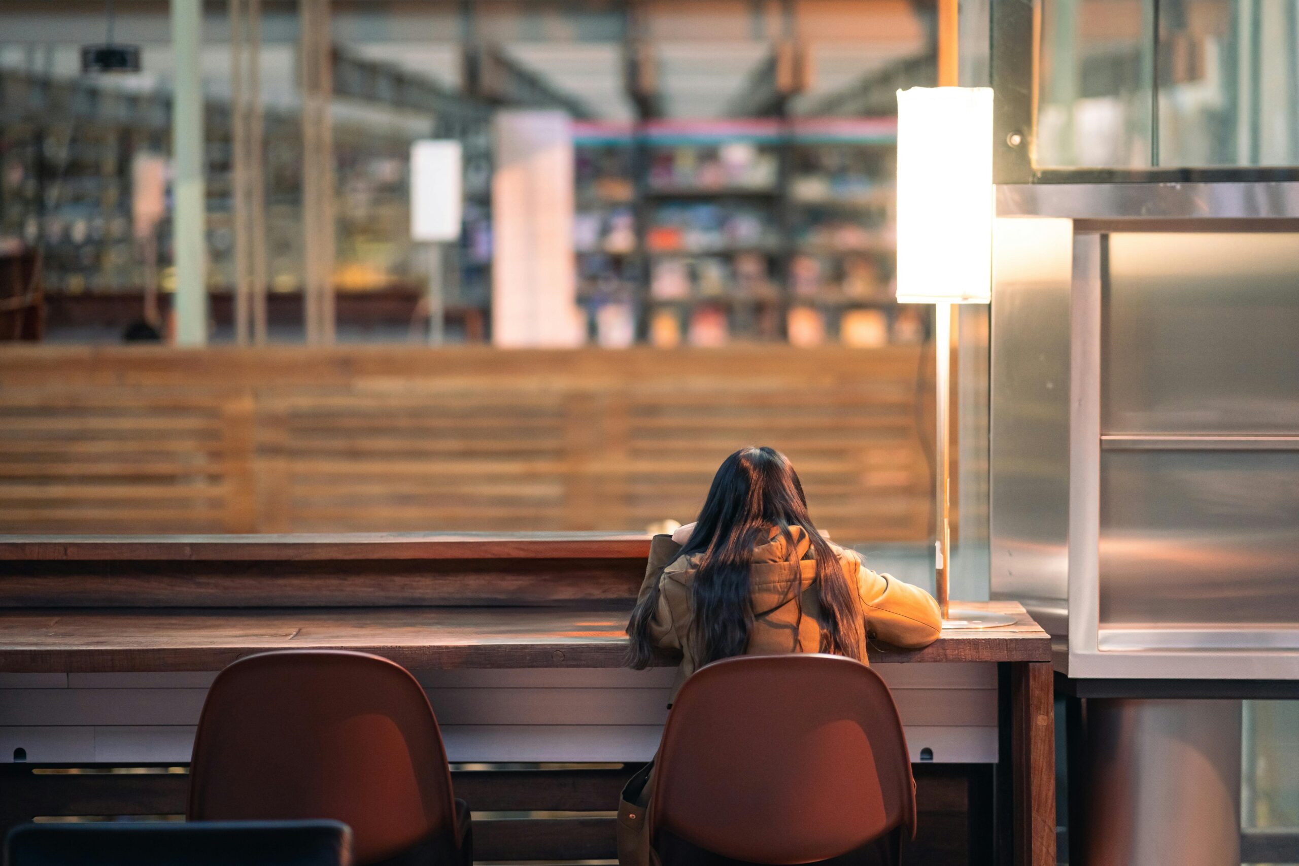 Junger Erwachsener lernt allein an einem Tisch in einer modernen Bibliothek in Mexiko-Stadt.